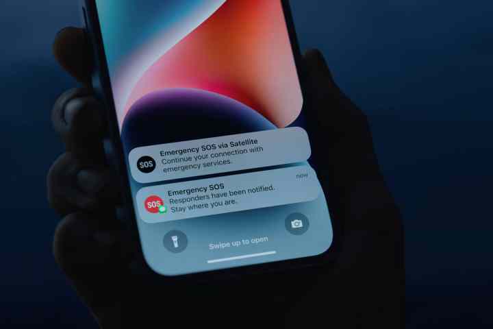 Pessoa segurando um iPhone 14 com SOS de emergência via notificações via satélite.