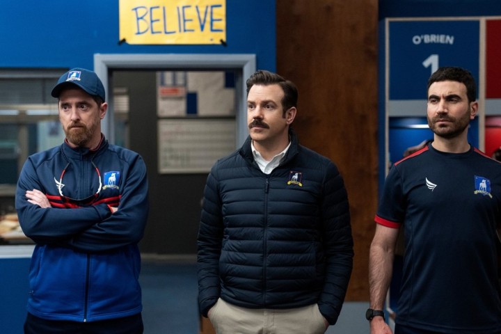 Ted e dois homens estão em um vestiário na terceira temporada de Ted Lasso.