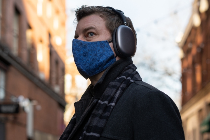 Um homem usa fones de ouvido Apple AirPods Max em uma rua da cidade.