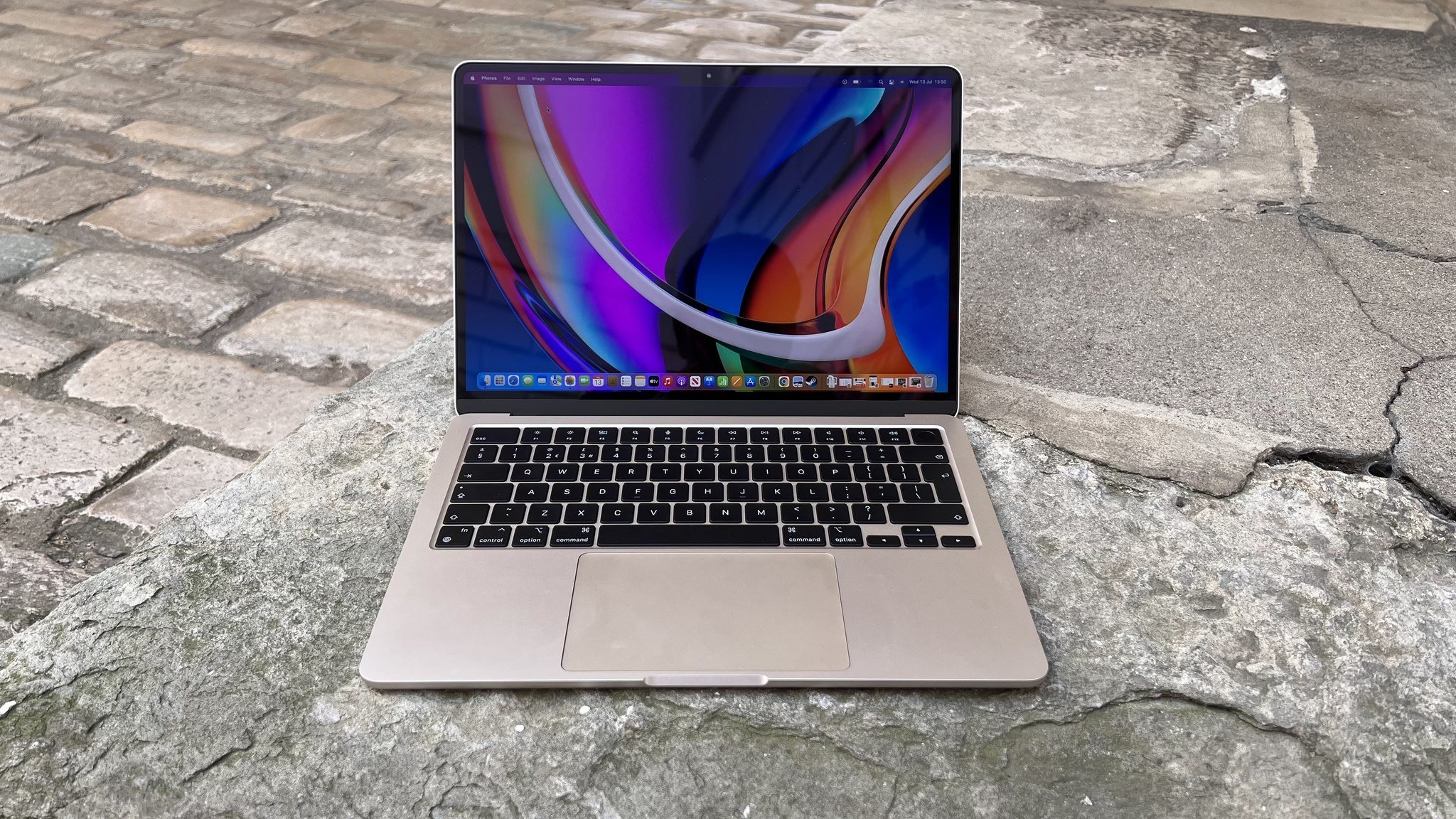 MacBook Air 2022 em chão de paralelepípedos