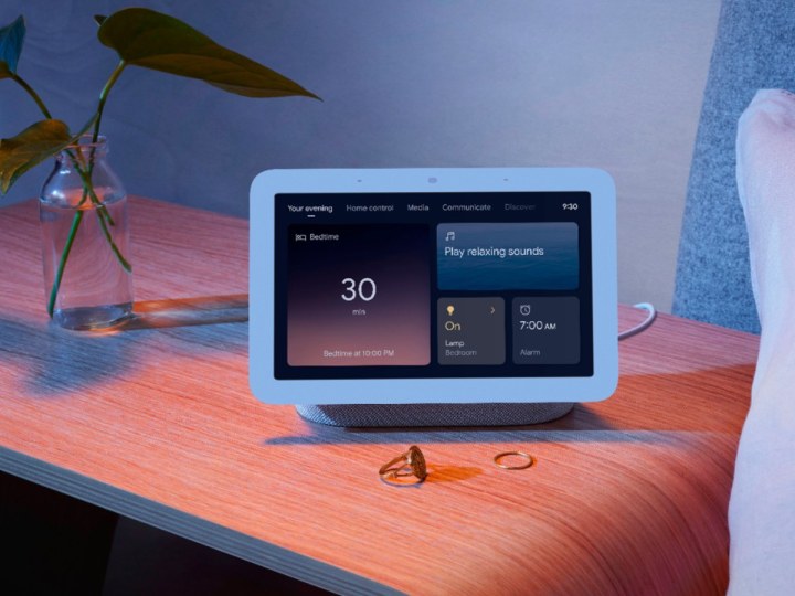 O Google Nest Hub Smart Display em uma mesinha de cabeceira.