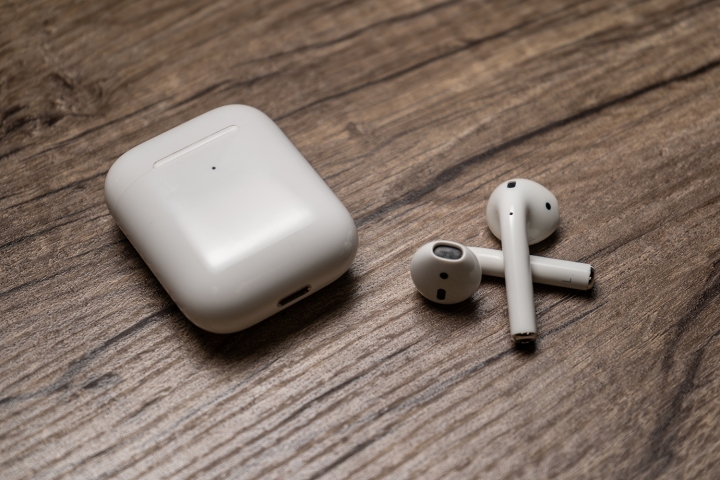 Os Apple AirPods de segunda geração ao lado do estojo de carregamento.