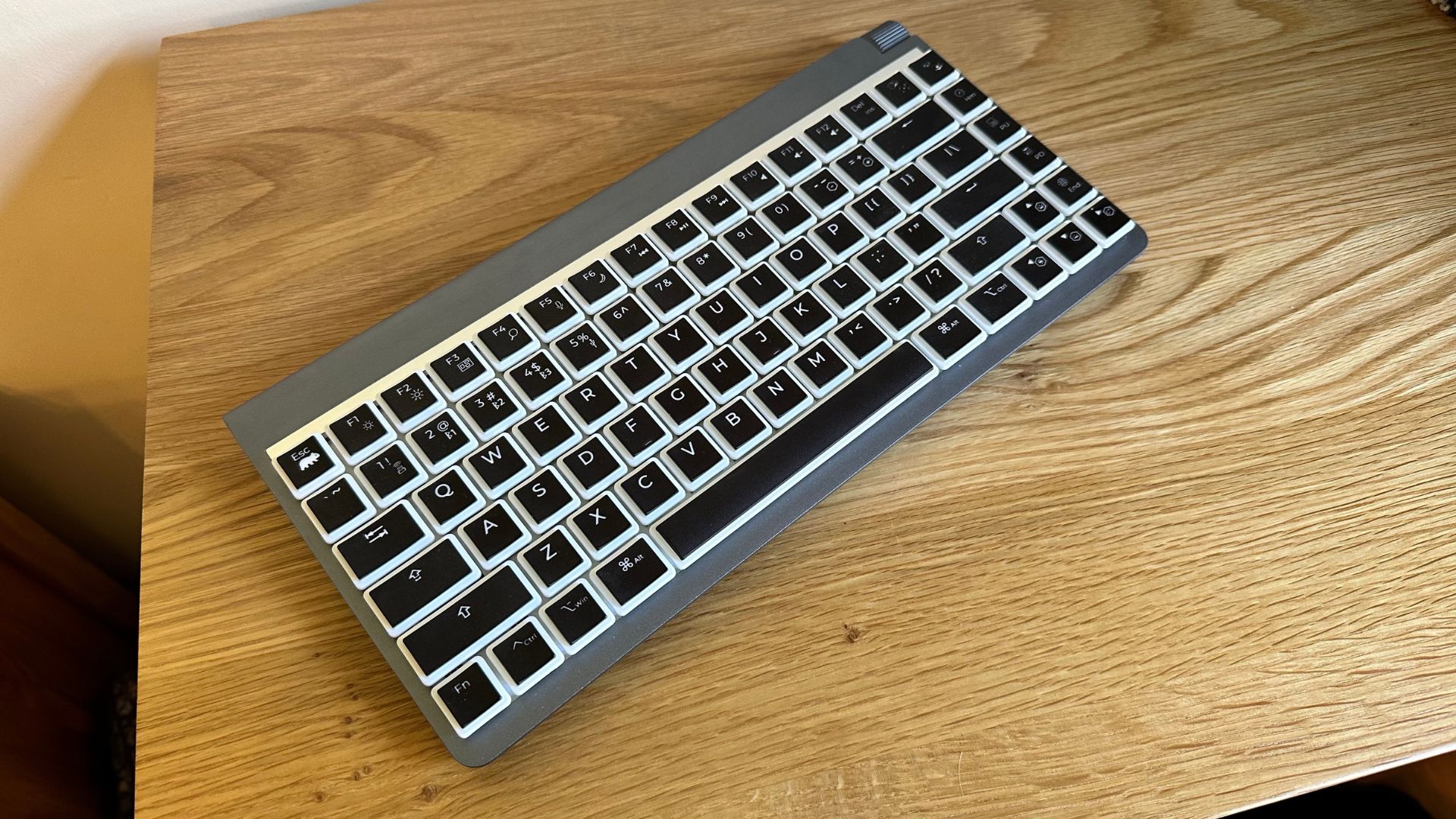 O teclado mecânico Wombat Coleus em uma superfície de madeira