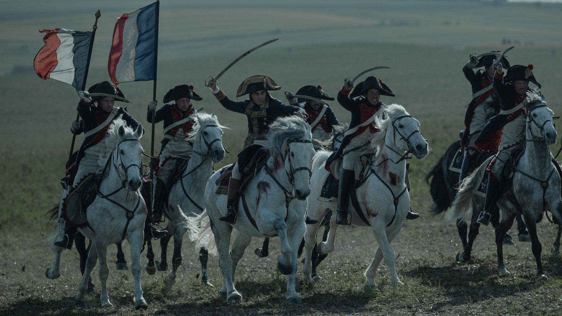 Uma imagem do filme Napoleão de Ridley Scott, com cavalos avançando para a batalha.