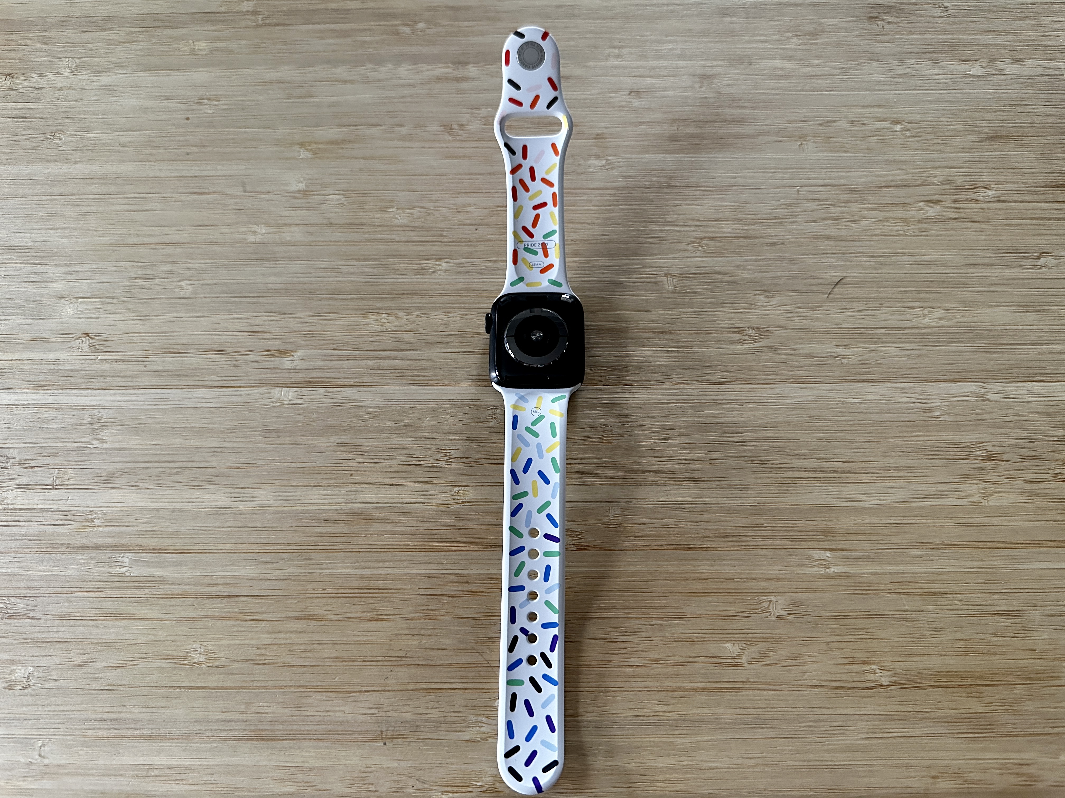 Parte traseira de um Apple Watch Series 5 com a pulseira esportiva 2023 Pride Edition