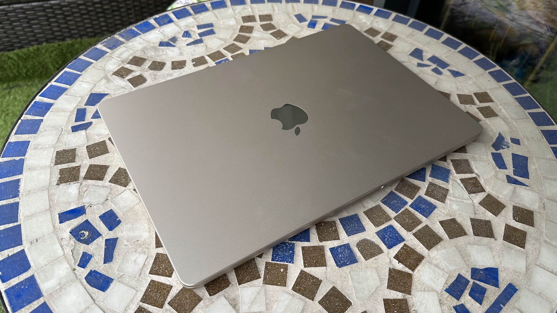 Em casa com o MacBook Air de 15 polegadas, sobre uma mesa de varanda em mosaico e piso de madeira.