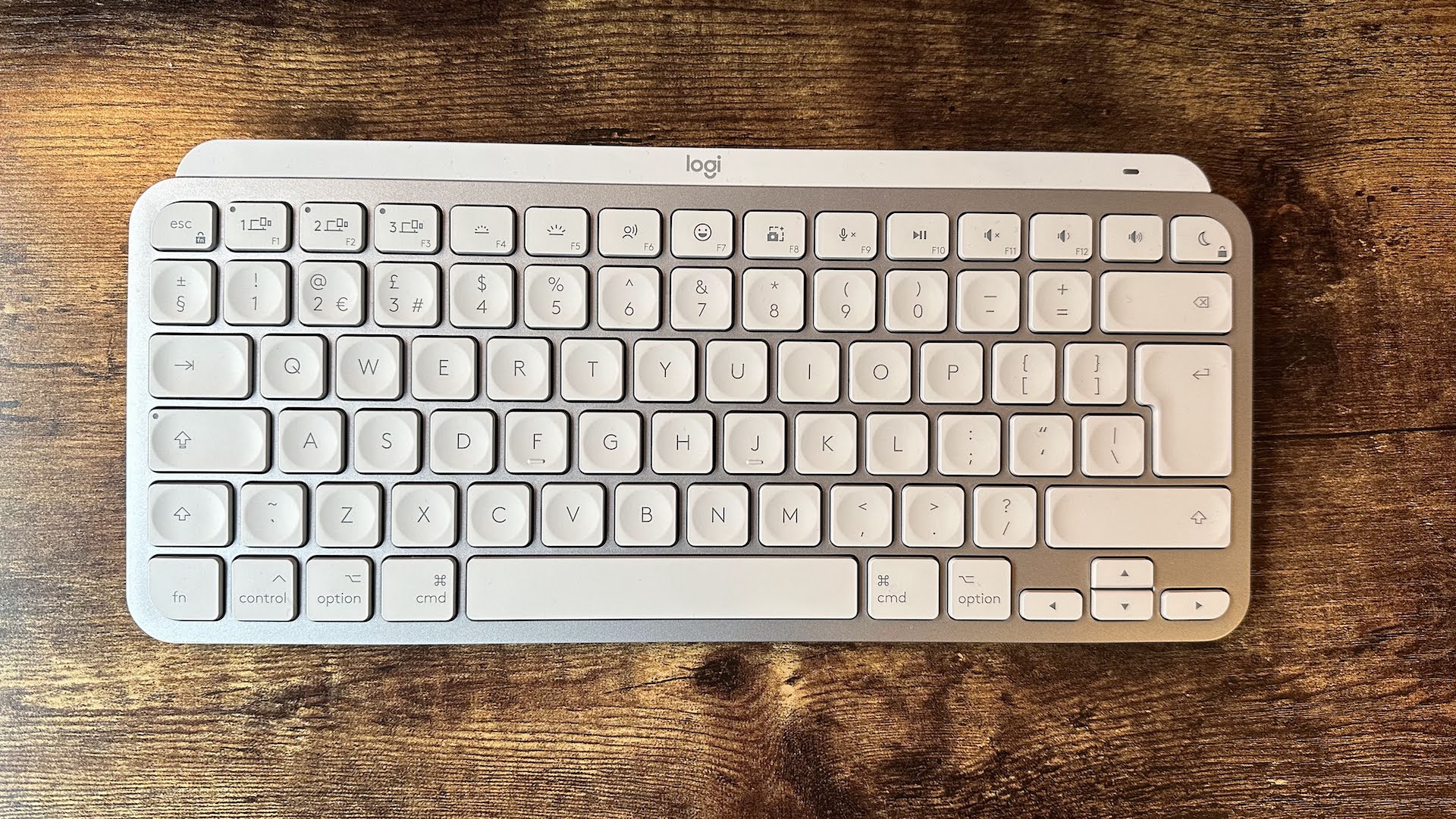 O teclado Logitech MX Keys Mini para Mac em uma mesa de madeira