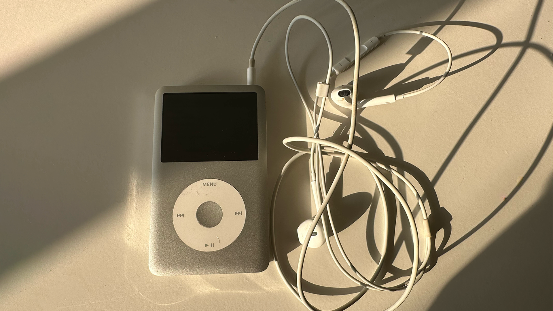 iPod Classic conectado a EarPods e cabo de carregamento