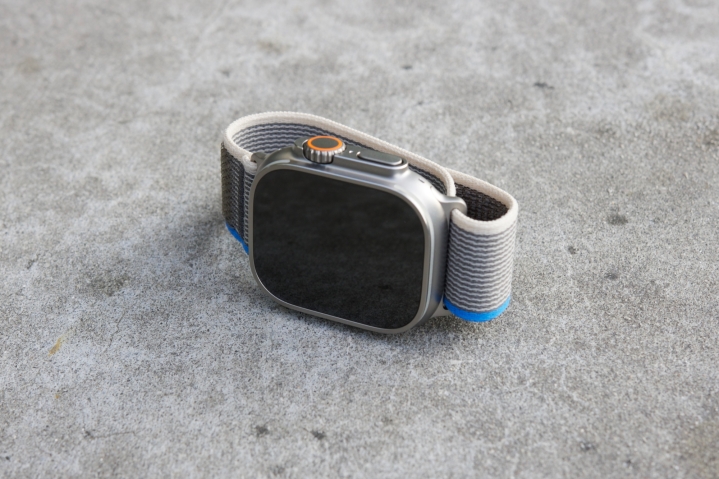 Apple Watch Ultra deitado de lado em um assento de concreto.