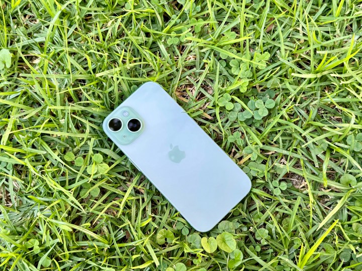 Um iPhone 15 verde na grama.