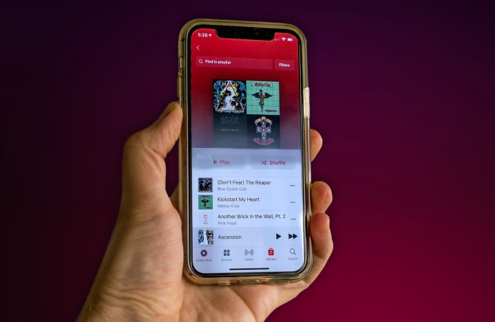 Uma pessoa segura um iPhone 11 com o aplicativo Apple Music aberto.