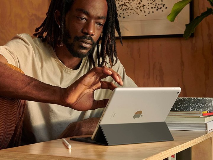 Um homem trabalha no Apple iPad 2021 em sua mesa.