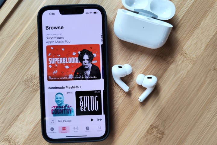 Apple AirPods Pro 2 ao lado do iPhone 14 e do estojo de carregamento.