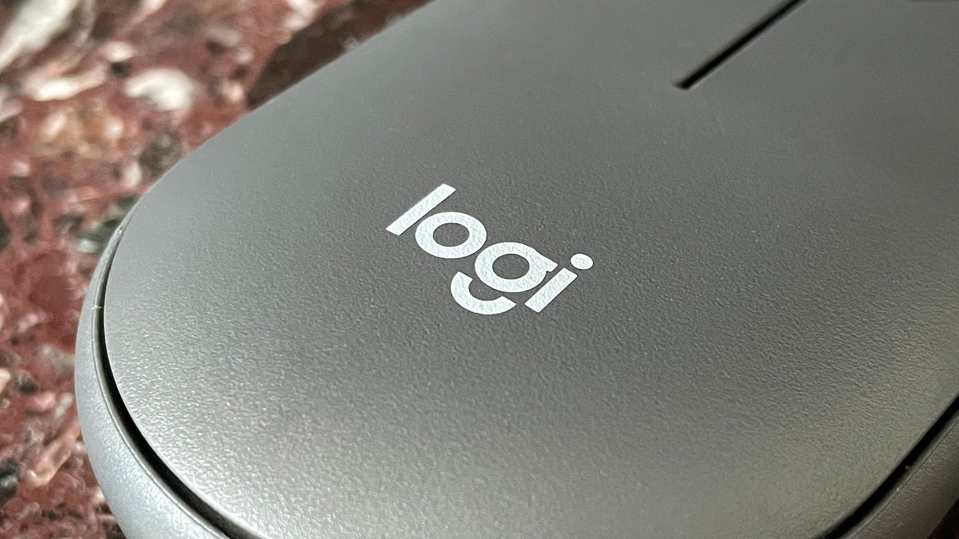 O logotipo da Logitech na parte traseira do mouse Logitech Pebble Mouse 2 M350S.