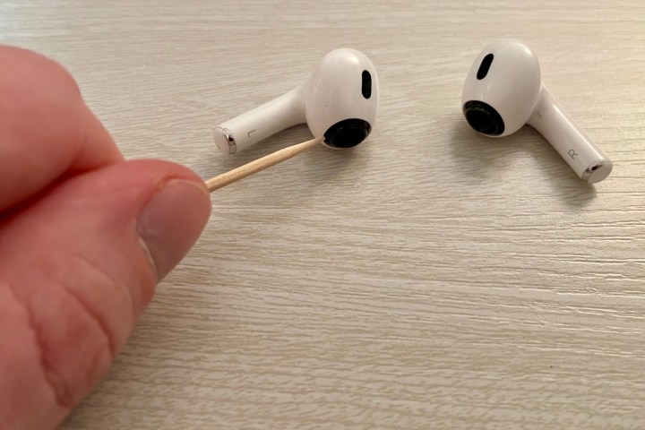 Limpando os drivers do AirPod Pro com um palito.