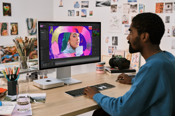 Alguém usando um Mac Mini sentado em uma mesa.