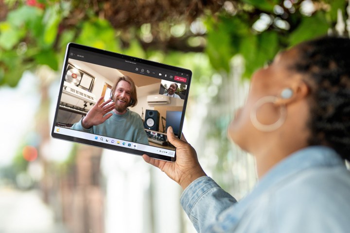 Vista frontal do Microsoft Surface Pro 9 mostrando tablet e videoconferência.