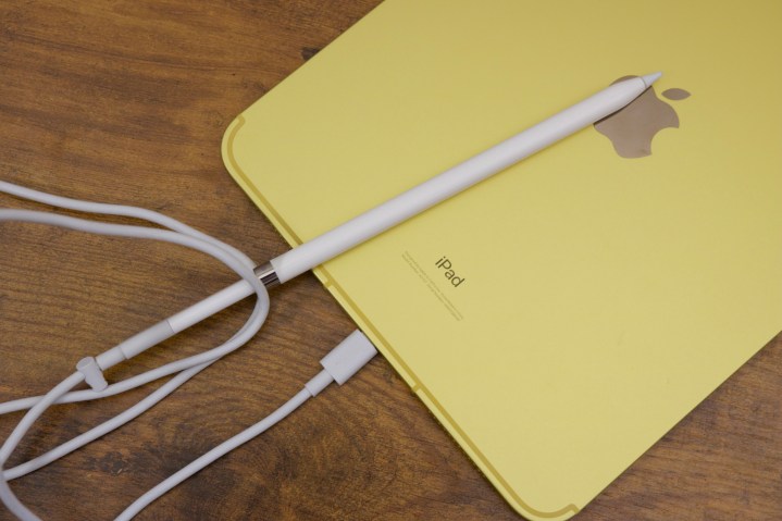 O iPad (2022) com um Apple Pencil conectado usando um cabo USB-C e adaptador.