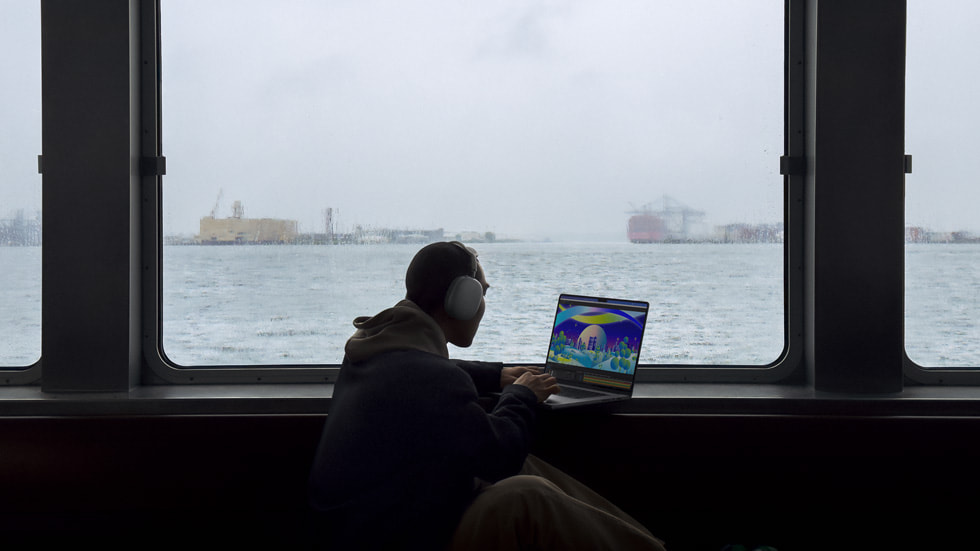 Alguém usa o MacBook Pro tendo como pano de fundo o oceano