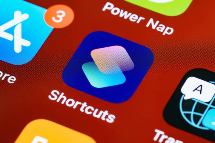 Uma foto em close do aplicativo Shortcuts em um dispositivo Apple, contra um fundo vermelho.