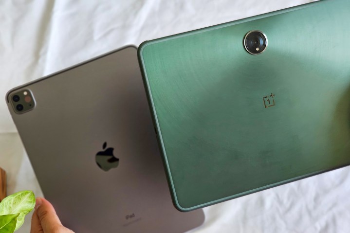 Homem segura tablet OnePlus Pad Android verde sobre M1 iPad Pro 2021 cinza espacial de 11 polegadas.