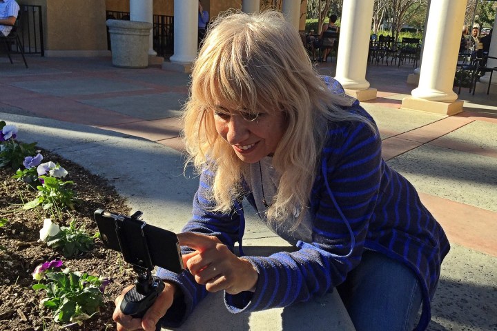 A diretora de cinema Susy Botello gravando vídeos em um telefone.