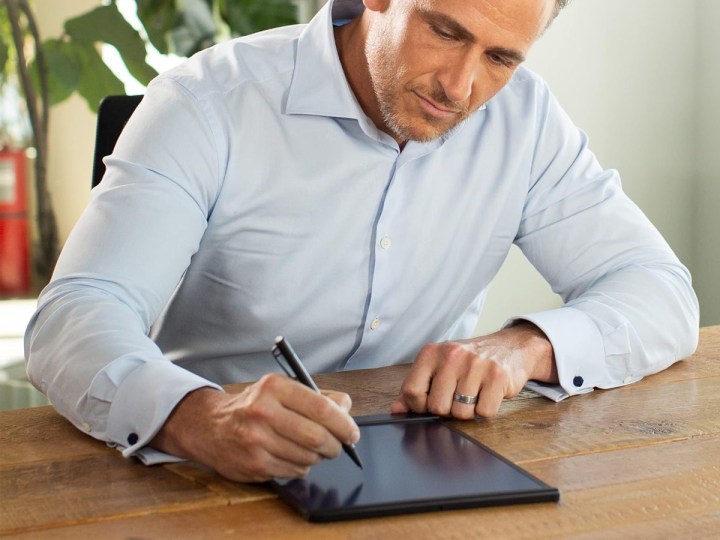 Um homem escreve no caderno inteligente Boogie Board Blackboard.