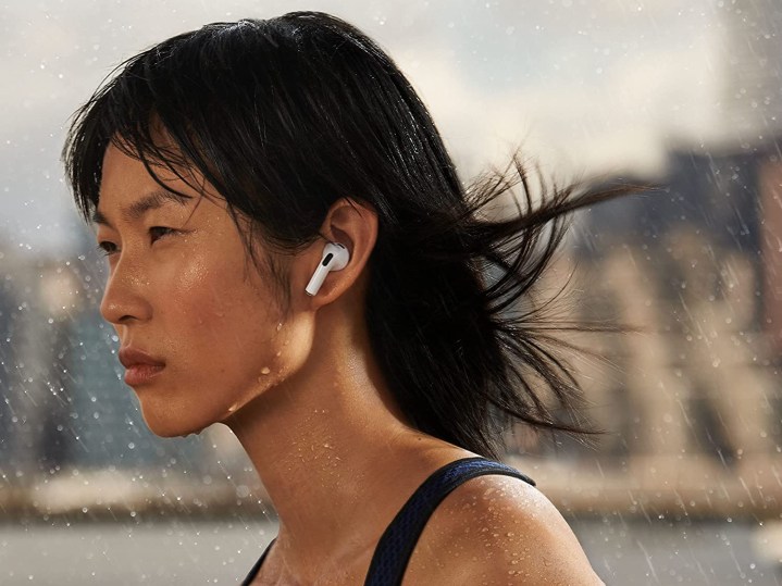 Uma mulher usando AirPods de 3ª geração enquanto se exercita.