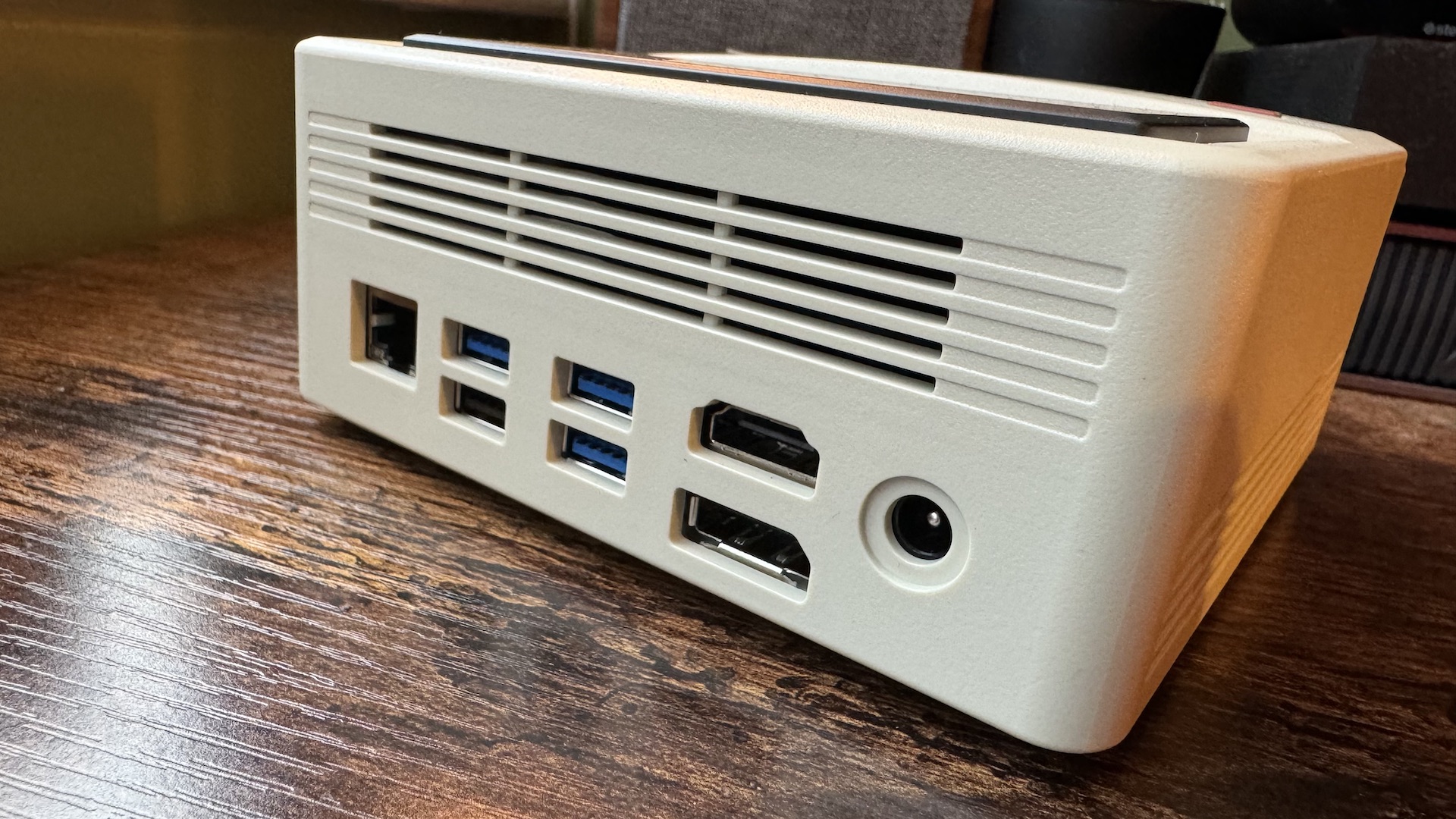 AyaNeo Retro Mini PC AM01 em uma mesa de escritório doméstico de madeira