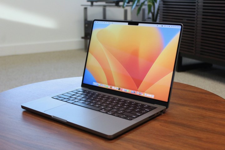 O MacBook Pro aberto sobre uma mesa de madeira.