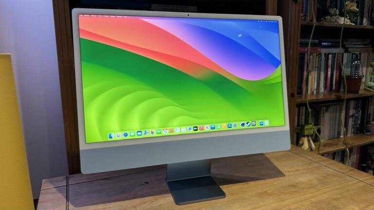 The 2023 M3 iMac on a wooden desk, showing the features of macOS Sonoma