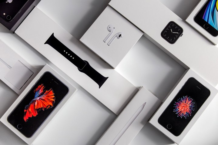 Caixas para Apple Watch, iPhones e Airpods ficam sobre uma mesa.