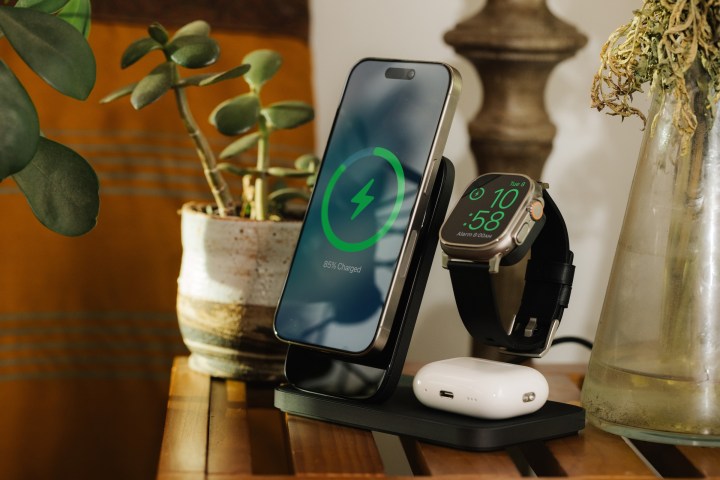 Suporte de carregamento Black Nomad Stand One Max na mesa doméstica com iPhone, Apple Watch Ultra e AirPods Pro acoplados e carregando.