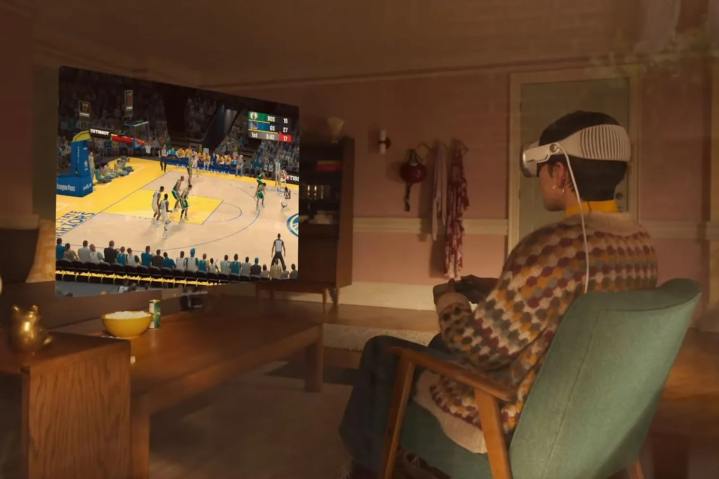 Uma pessoa joga basquete usando um headset Apple Vision Pro e um controlador de jogos.
