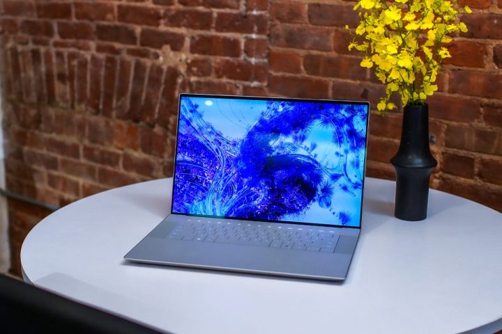 Dell XPS 16 sentado na área de trabalho com flores.