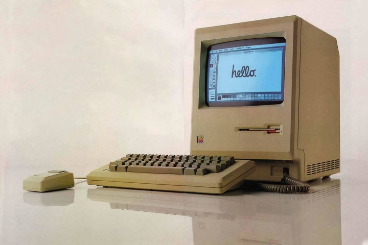 Um Apple Macintosh clássico mostra um alô amigável na tela.