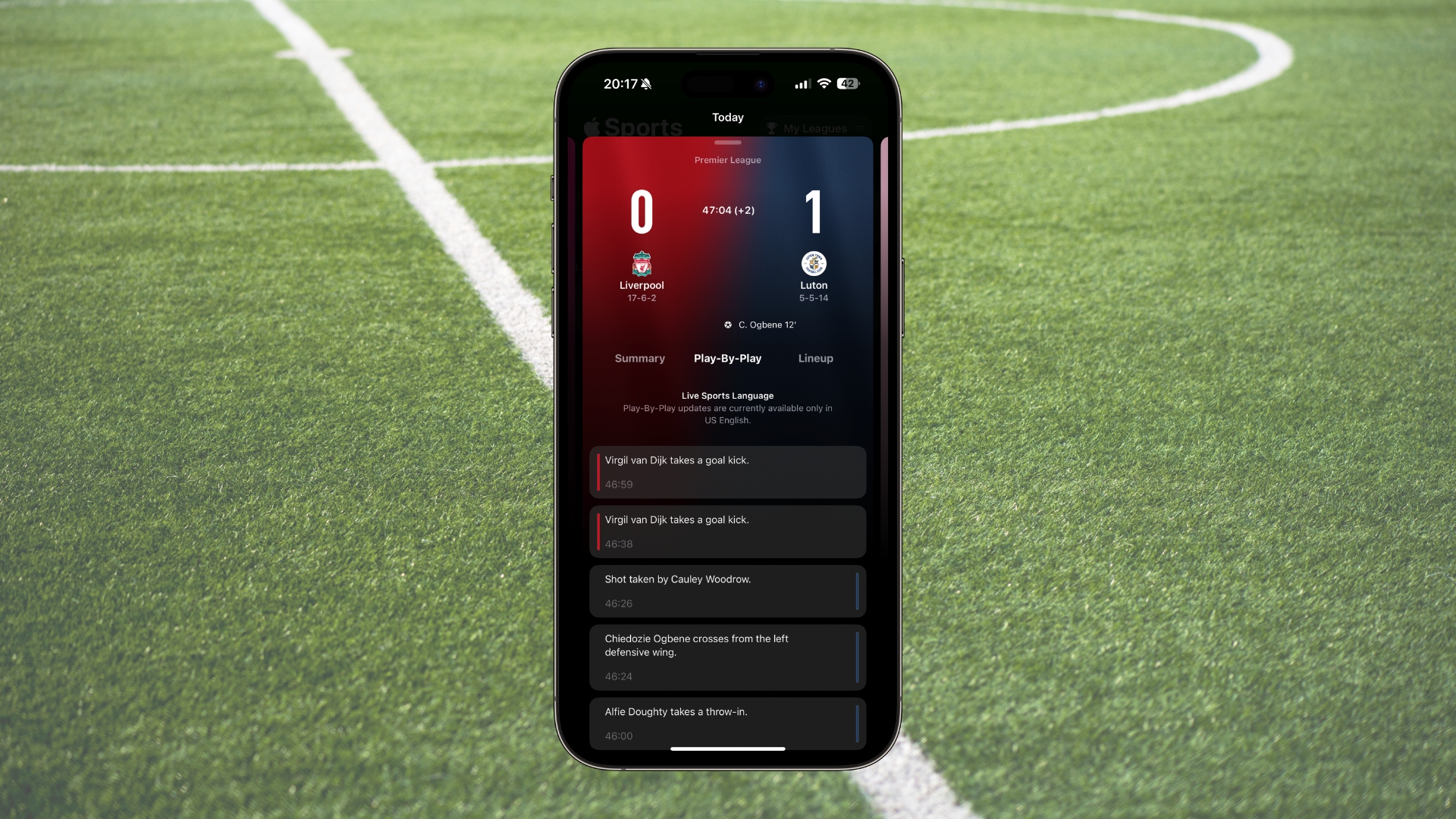 Apple Sports em uma moldura de iPhone 15 Pro Max com um campo de futebol como plano de fundo