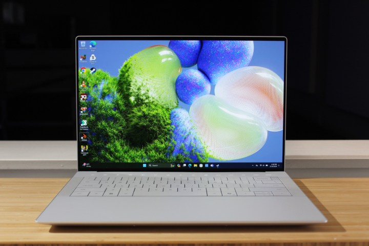 O Dell XPS 14 aberto sobre uma mesa de madeira.