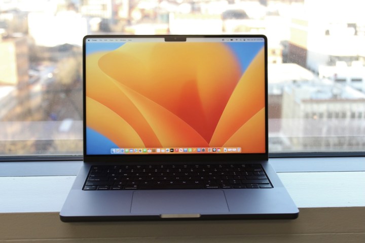 O MacBook Pro de 14 polegadas no parapeito de uma janela.