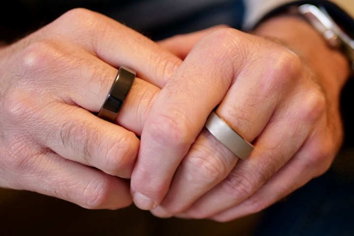 Uma pessoa usando o Oura Ring e o RingConn Smart Ring.