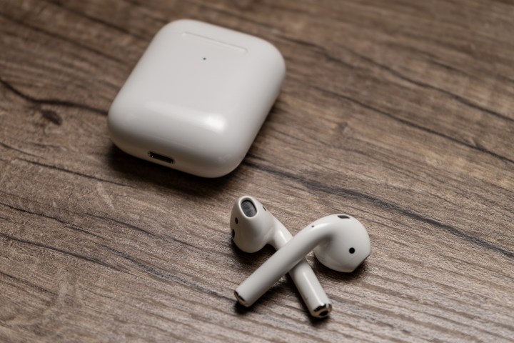 Apple AirPods colocados em uma mesa ao lado do estojo de carregamento