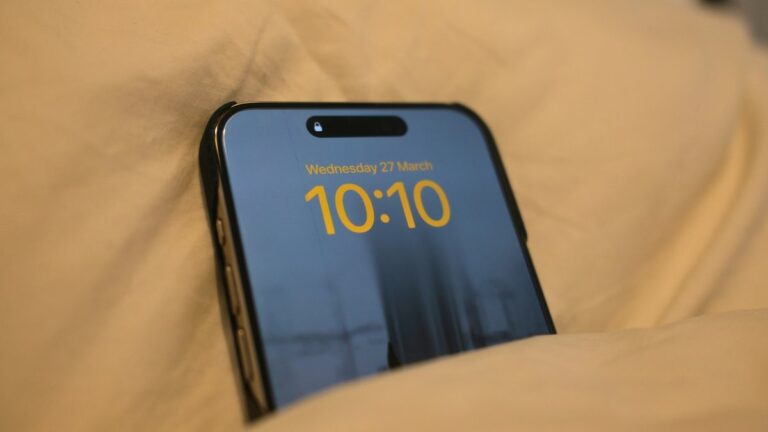 An iPhone 15 Pro Max in bed with low brightness