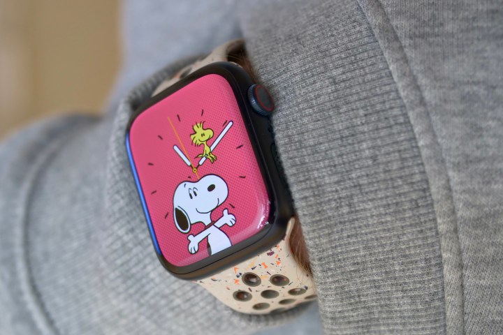 Uma pessoa usando o Apple Watch Series 9, mostrando o mostrador do Snoopy