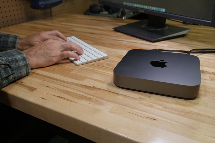 O Apple Mac Mini sendo usado em uma mesa de madeira.