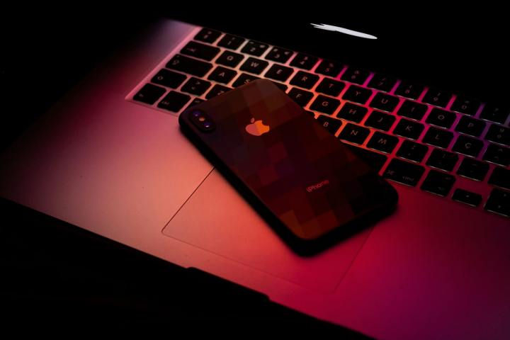 Um MacBook e um iPhone em luz vermelha escura.