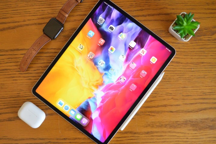 O iPad Pro em uma mesa ao lado de uma caneta e AirPods.